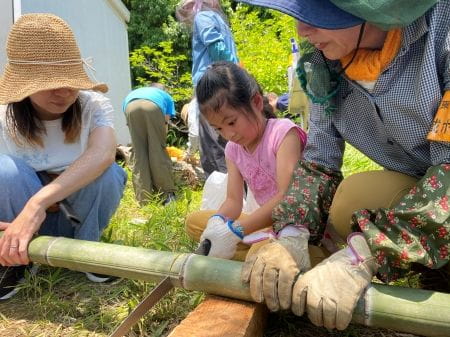 竹をノコギリで切る様子