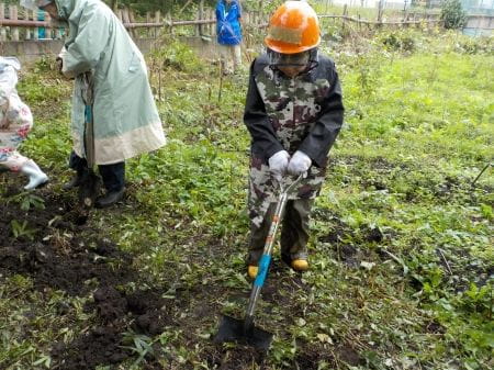 スコップで土を掘る様子