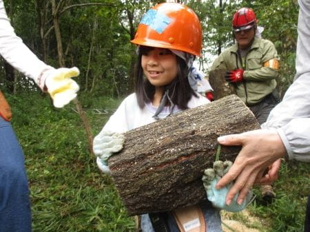 丸太を抱える少女