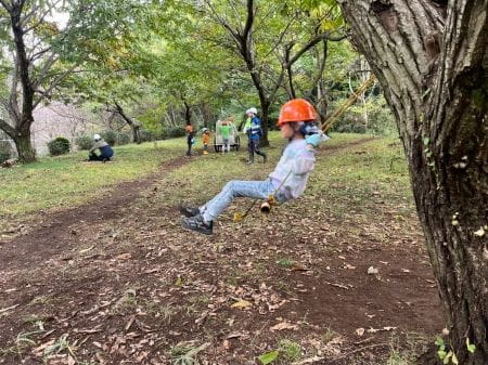 すっきりした広場のブランコをこぐ子ども