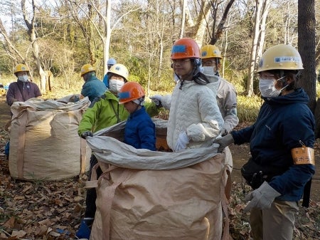 トン袋の中に入って足で落ち葉を踏み固める様子