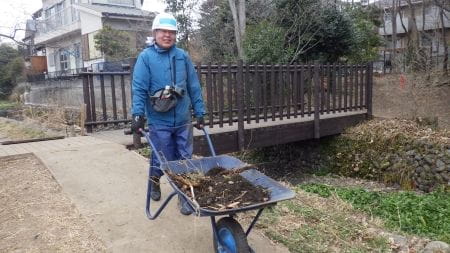 一輪車で土を運ぶ参加者